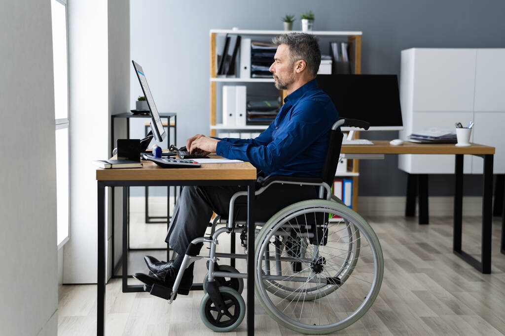 Людина з обмеженими можливостями в інвалідному візку використовуючи комп'ютерні технології
 - Фото, зображення