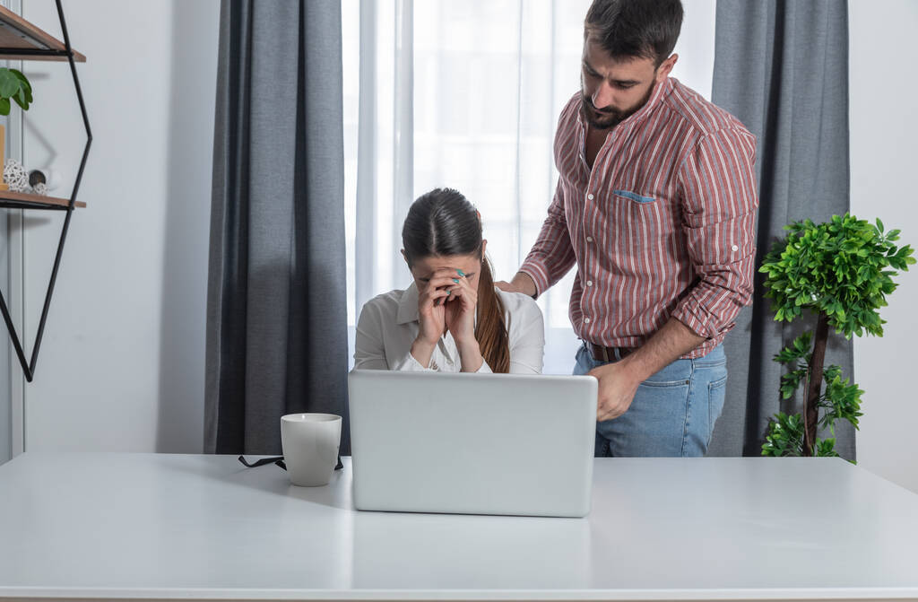 Молодая женщина работница допустил ошибку в программе на компьютере и очень расстроен и коллега мужчина утешает ее, потому что она исправит ошибку - Фото, изображение
