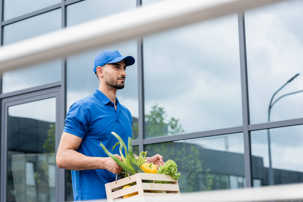 Arabischer Kurier hält Box mit Gemüse im Freien  - Foto, Bild