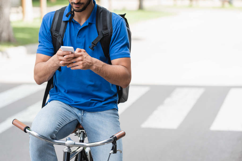 屋外で自転車に乗っている間にスマートフォンを使用して宅配便の作物ビュー  - 写真・画像