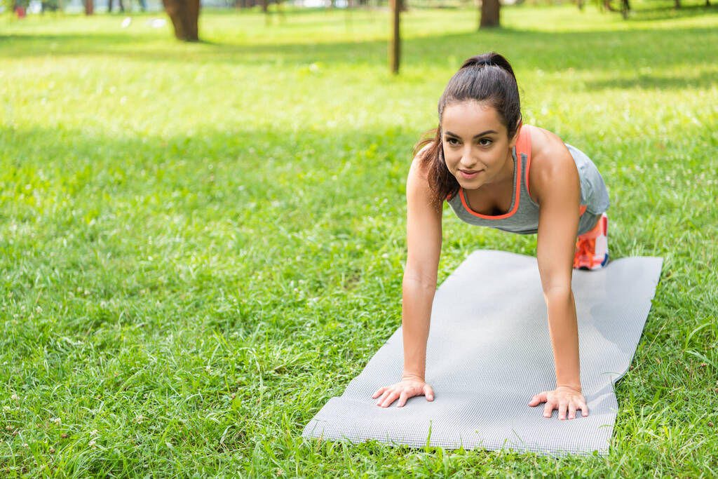 usmívající se mladá fit žena dělá prkno na fitness podložku  - Fotografie, Obrázek