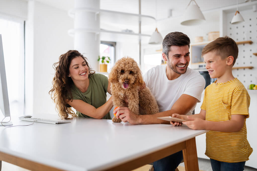 Joyeux jeune famille avec des appareils modernes et chien s'amuser, jouer à la maison - Photo, image
