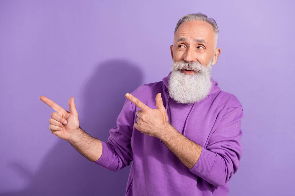 魅力的な高齢者の肖像画引退したトレンディーな白髪の男紫色の背景に隔離されたコピースペースソリューションを示す - 写真・画像