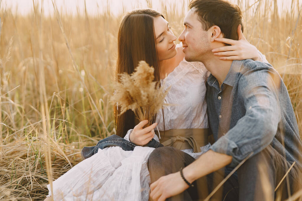 Onnellinen pari rakastunut vehnäpellolla auringonlaskun aikaan - Valokuva, kuva