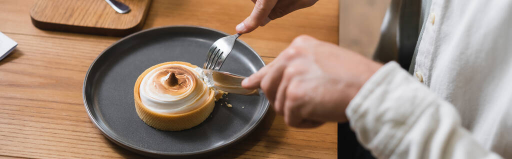 oříznutý pohled na muže držícího příbory u citrónové koláče na talíři, prapor - Fotografie, Obrázek