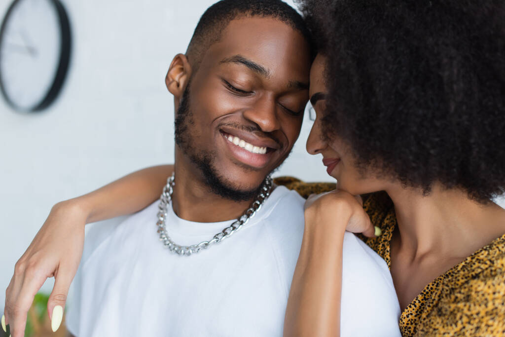 Giovane donna afroamericana che abbraccia il fidanzato a casa  - Foto, immagini