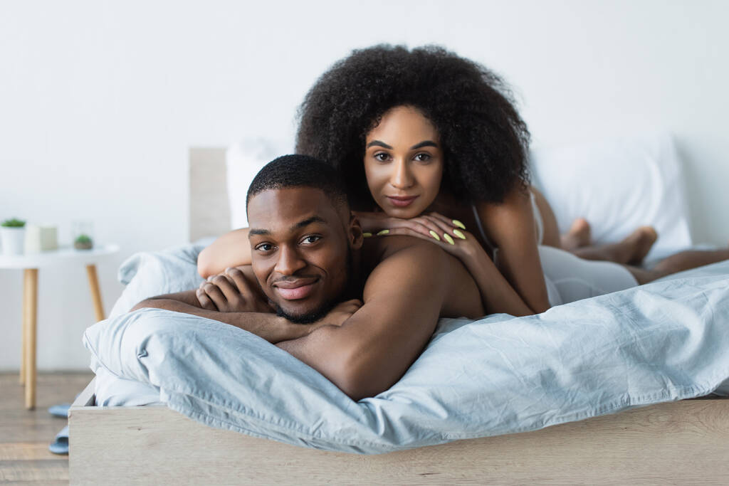 Mladý africký americký pár ležící na posteli doma  - Fotografie, Obrázek