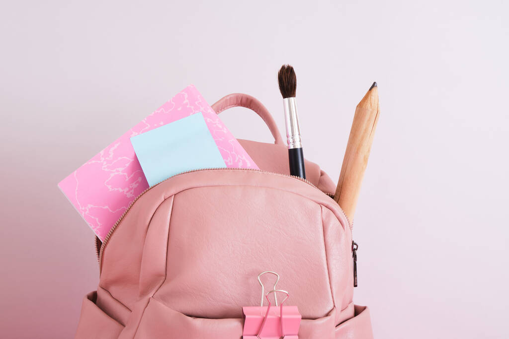 kožený růžový batoh přes rameno na šedém pozadí, školní dámský batoh s velkou velrybou, velká tužka a notebook, zpět do školy - Fotografie, Obrázek