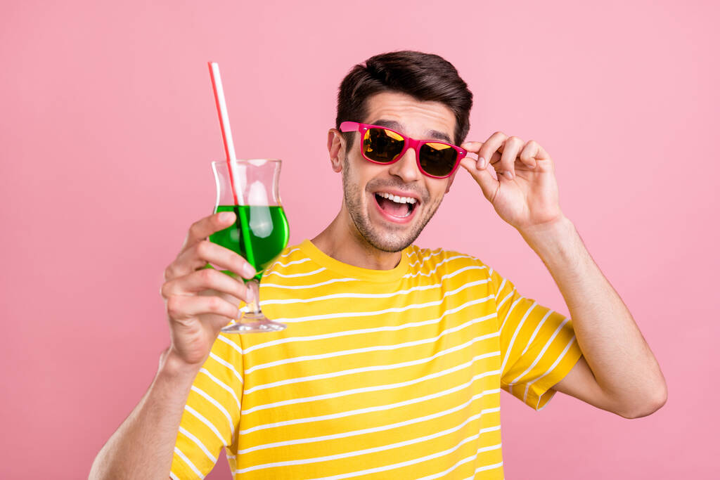 Kuva onnellinen viehättävä iloinen mies pitää cocktail hurraa kulumista aurinkolasi eristetty vaaleanpunainen väri tausta - Valokuva, kuva