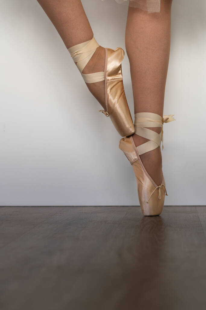 πόδια του κοριτσιού χορό μπαλέτο με τούλι φούστα και ροζ παπούτσια διαφορετικά βήματα χορού ξύλινο πάτωμα και λευκό φόντο με αντίγραφο χώρο - Φωτογραφία, εικόνα