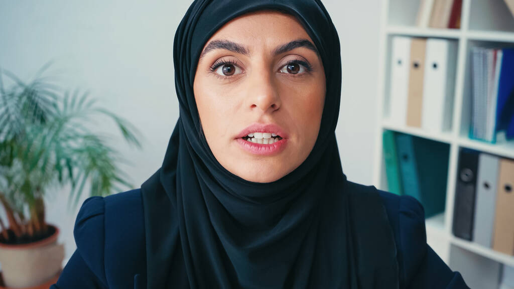 muslim επιχειρηματίας σε hijab μιλάμε, ενώ κοιτάζοντας κάμερα - Φωτογραφία, εικόνα