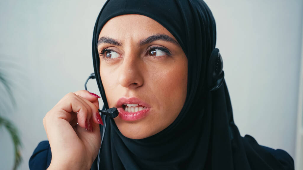 femme dans hijab en utilisant le microphone tout en parlant au bureau  - Photo, image