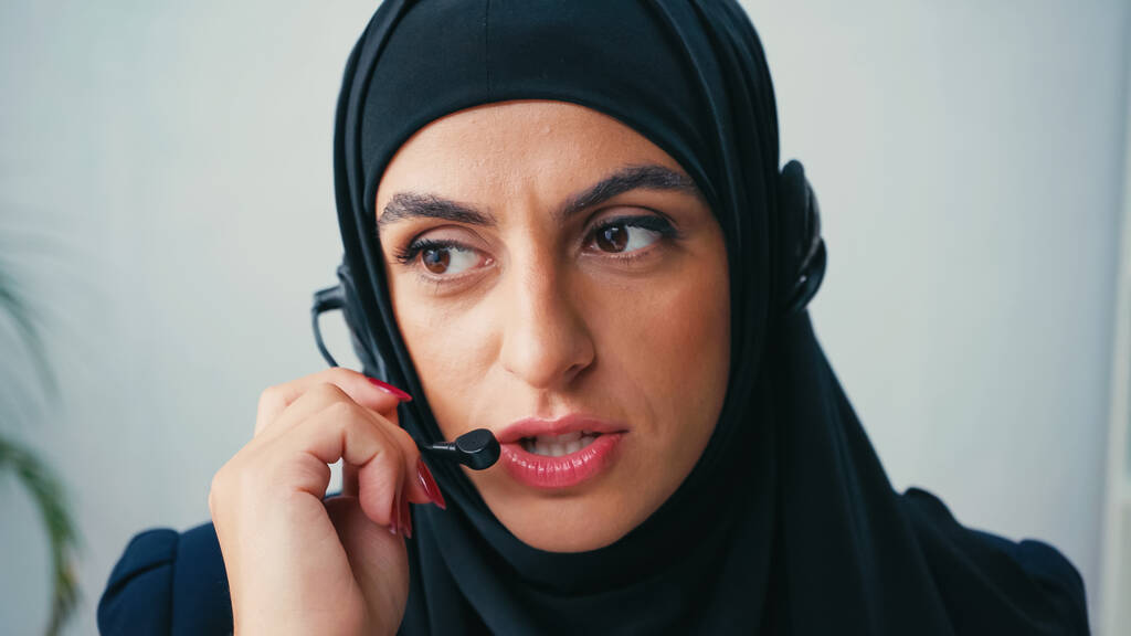 nainen hijabissa mikrofonilla puhuessaan puhelinkeskuksessa  - Valokuva, kuva