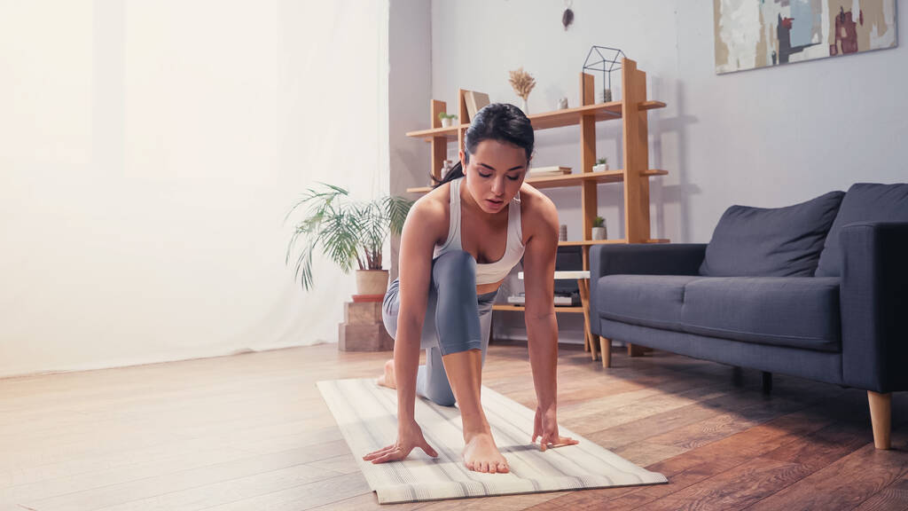Sportnő edz otthon fitnesz szőnyegen  - Fotó, kép