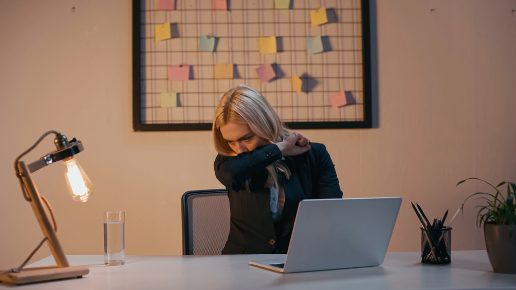 Хвора бізнес-леді кашляє біля робочого столу в офісі
  - Фото, зображення