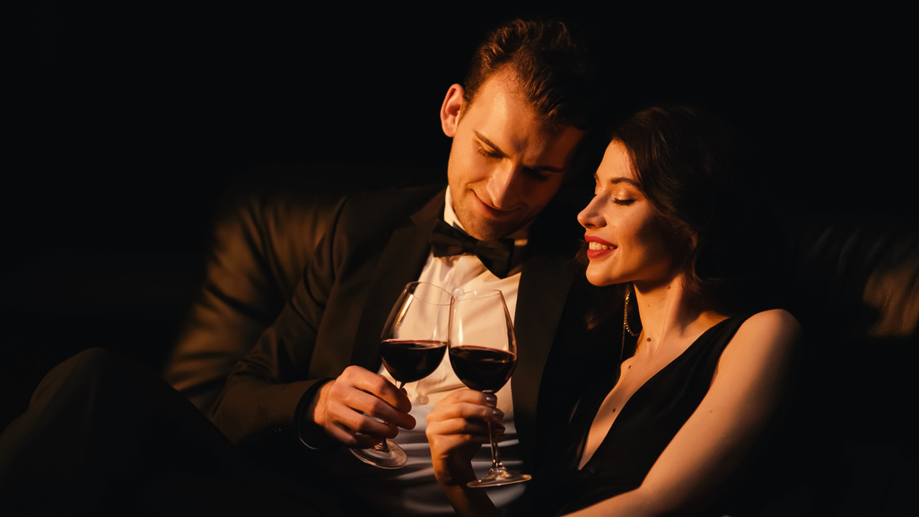 ブラックに隔離された赤ワインの明るいカップルクリンクグラス - 写真・画像