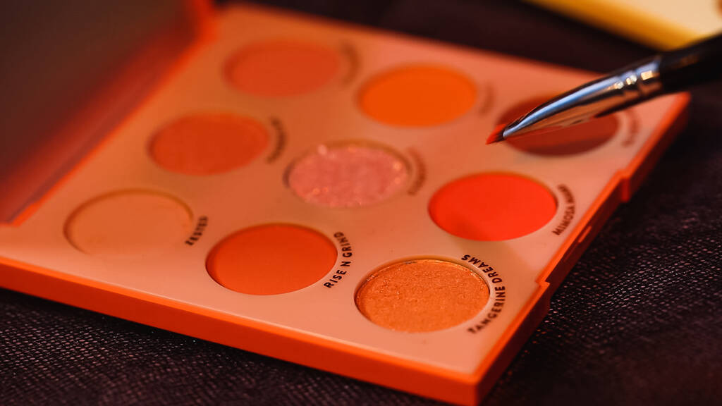 Kosmetikpinsel nahe Palette mit unterschiedlichem Lidschatten  - Foto, Bild