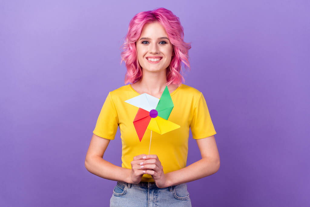 Photo of young attractive girl happy positive smile origami pin windmill paper isolated over purple color background - Photo, Image