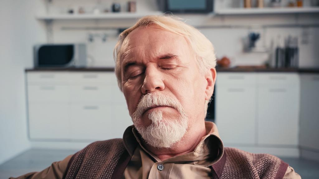 bärtiger älterer Mann mit geschlossenen Augen schläft zu Hause - Foto, Bild