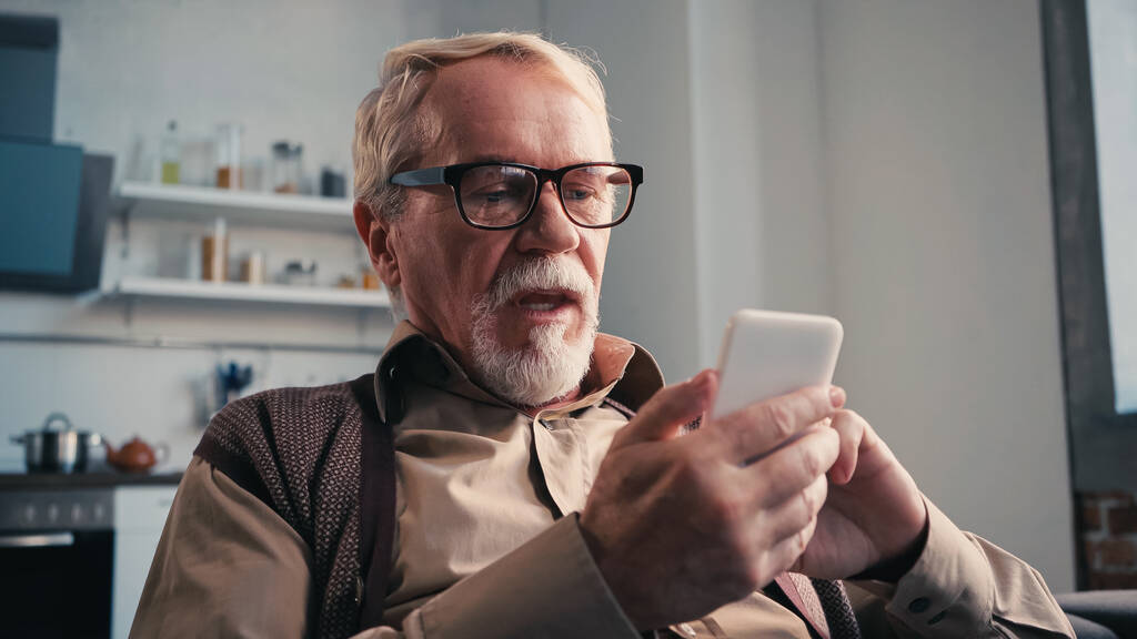 hombre mayor con gafas de vista usando smartphone  - Foto, imagen