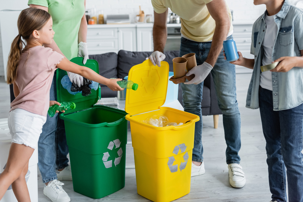 Děti držící odpadky poblíž rodičů v latexových rukavicích a plechovkách se značkou recyklace  - Fotografie, Obrázek
