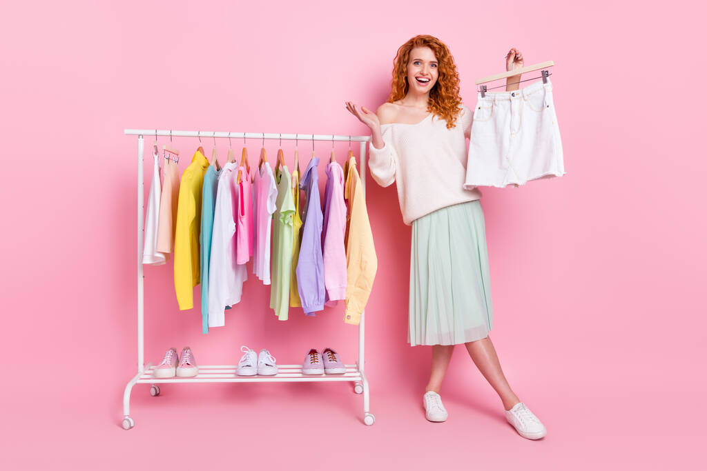 Pleine photo du corps de la jeune fille heureux sourire positif garde-robe acheter jupe de nouvelles isolé sur fond de couleur rose - Photo, image