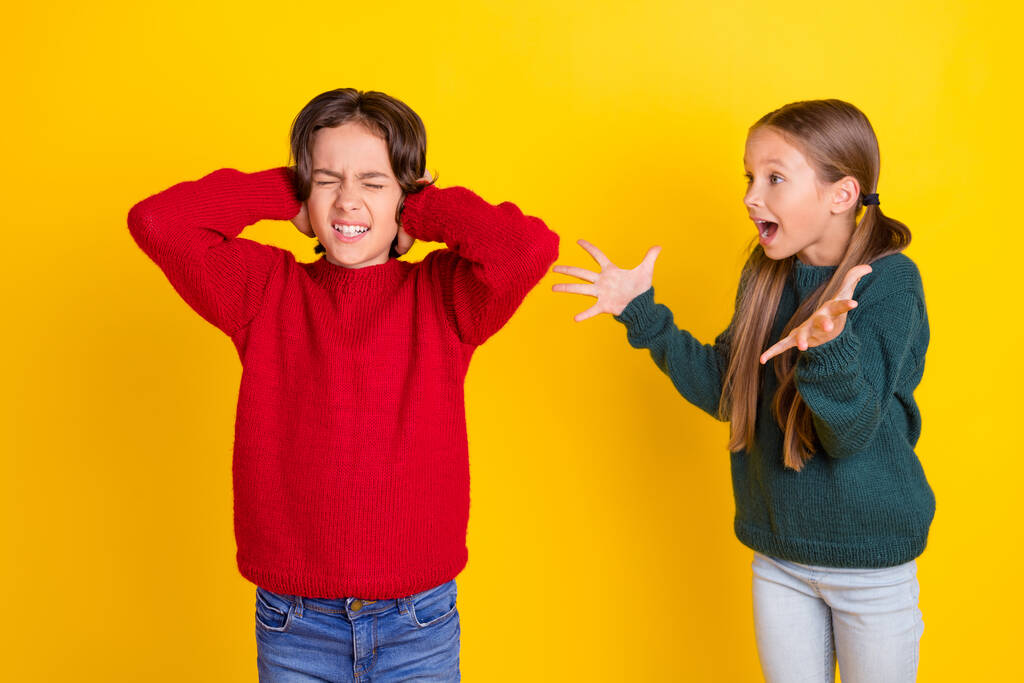 Zdjęcie portret dwoje dzieci krzyczy kłócąc się odizolowane jasnożółty kolor tła - Zdjęcie, obraz