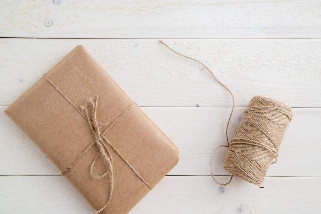 parcel,gift Packed in eco-friendly paper and twine for packing on light wooden background. the view from the top - Photo, Image