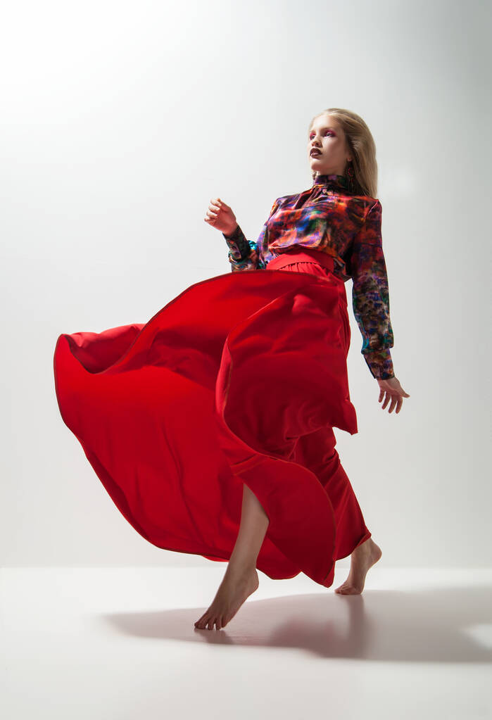 Φωτογραφία μόδας της νεαρής γυναίκας με κόκκινο φόρεμα. Στούντιο - Φωτογραφία, εικόνα