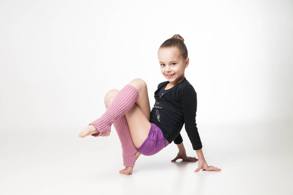 sevimli küçük kız beyaz arka plan üzerinde jimnastik yapıyor - Fotoğraf, Görsel
