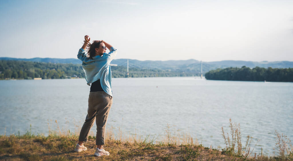 Glücklich schöne erwachsene Frau Mitte genießen Aussicht und Landschaft am Flussufer - Foto, Bild