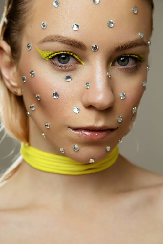 Studio portret pięknej dziewczyny z kreatywnym jasny żółty makijaż z kryształów - Zdjęcie, obraz