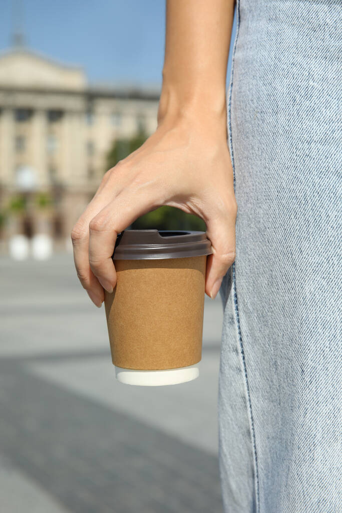 Nő kezében elvitelre karton csésze műanyag fedél szabadban, közelkép - Fotó, kép