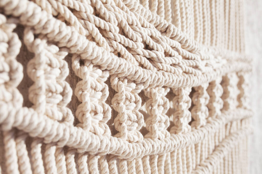 Zbliżenie ręcznie wykonane makramy wzór tekstury. ECO friendly modern knitting DIY naturalna koncepcja dekoracji wnętrz. Ręcznie robione makramy 100% bawełny. Kobiece hobby. - Zdjęcie, obraz