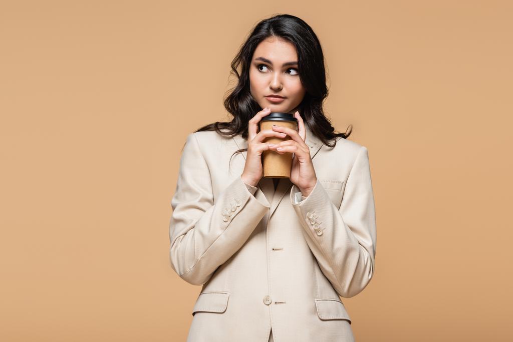 mladá žena v roláku a oblek drží kávu jít izolované na béžové - Fotografie, Obrázek