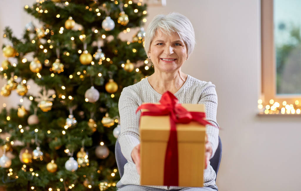Felice donna anziana con regalo di Natale a casa
 - Foto, immagini