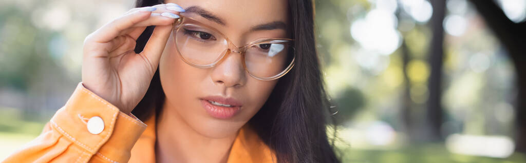 réfléchi asiatique femme ajustement lunettes de vue à l'extérieur, bannière - Photo, image
