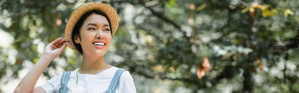 szczęśliwy Azji kobieta w słomiany kapelusz patrząc daleko na zewnątrz, sztandar - Zdjęcie, obraz