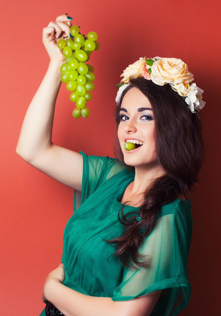 vrouw dragen krans en bedrijf groene druiven - Foto, afbeelding