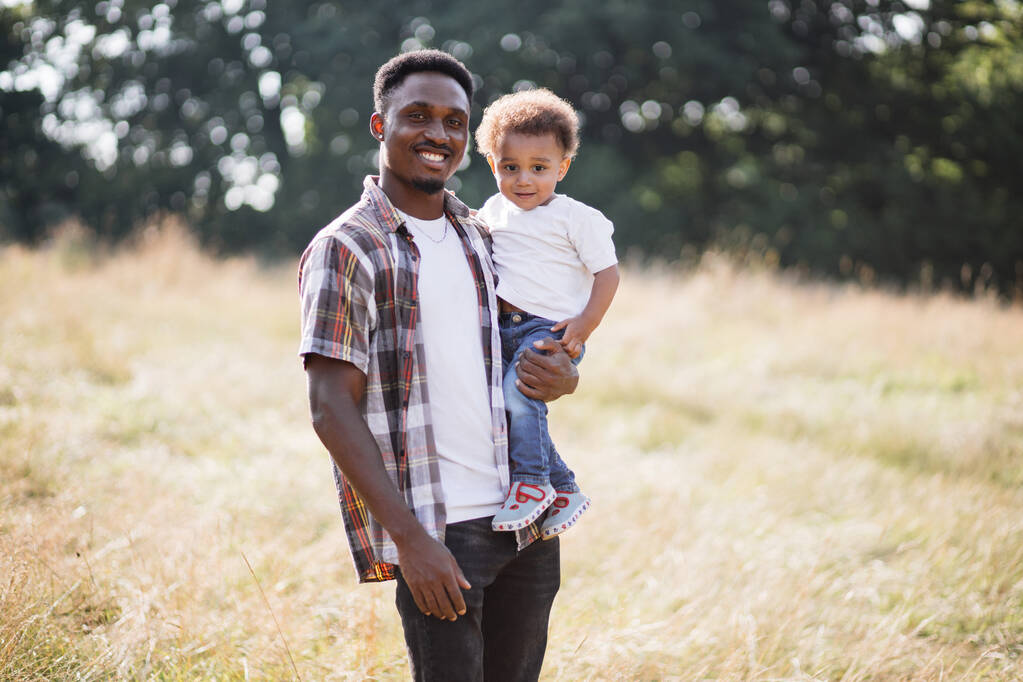 Africain posant avec petit fils sur le champ d'été - Photo, image