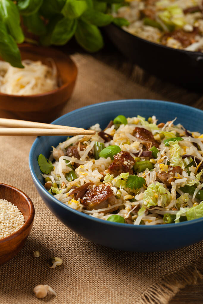 Τηγανητό μοσχάρι, με ρύζι, κινέζικο λάχανο και μανιτάρια. Πασπαλισμένο με σουσάμι και σάλτσα σόγιας. Πρόσθια όψη.  - Φωτογραφία, εικόνα
