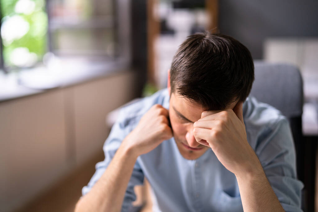 Tyytymätön surullinen mies migreenin kanssa kannettavan tietokoneen avulla - Valokuva, kuva