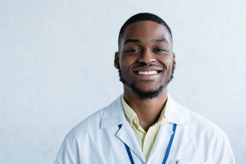 若く明るいアフリカ系アメリカ人の医師が白いカメラを見て - 写真・画像