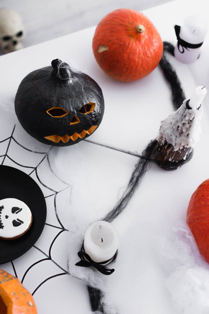 bovenaanzicht van pompoenen en gebakken koekje en kaarsen op halloween party - Foto, afbeelding