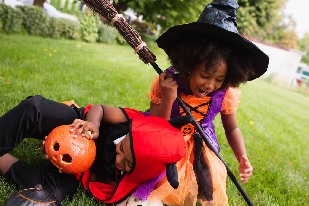 irmãos afro-americanos em trajes de Halloween gritando enquanto brincavam no quintal - Foto, Imagem