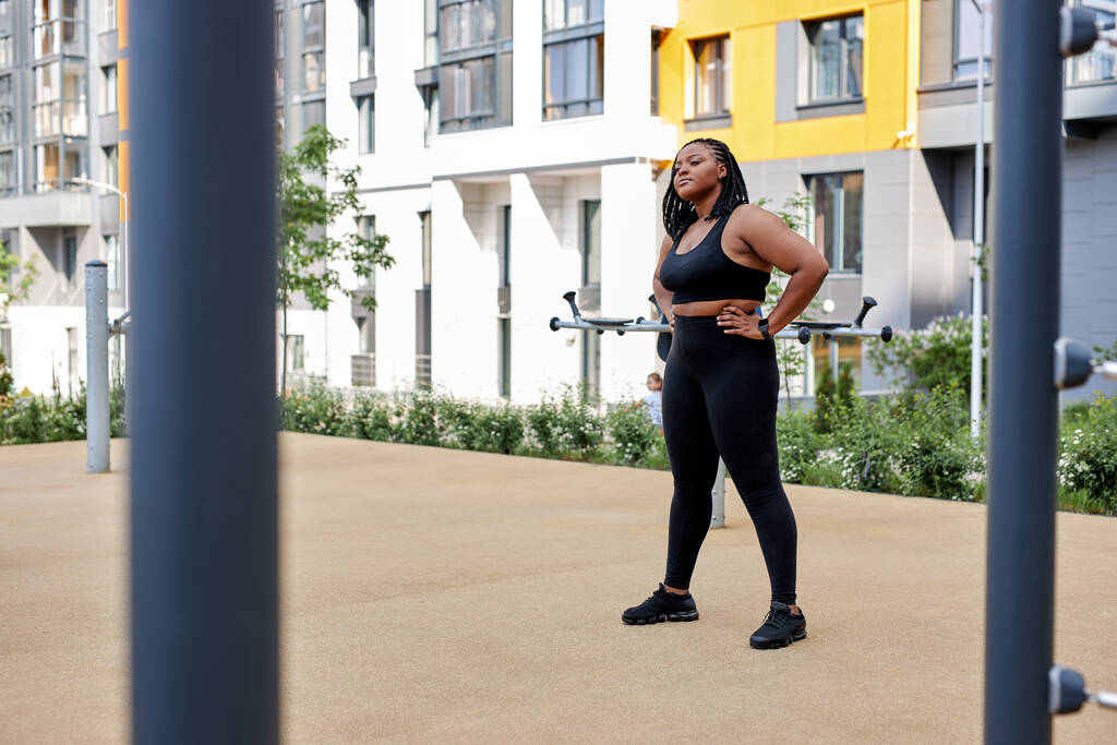 Beautiful african overweight young woman does fitness outdoors. Fat lady is training - Photo, Image