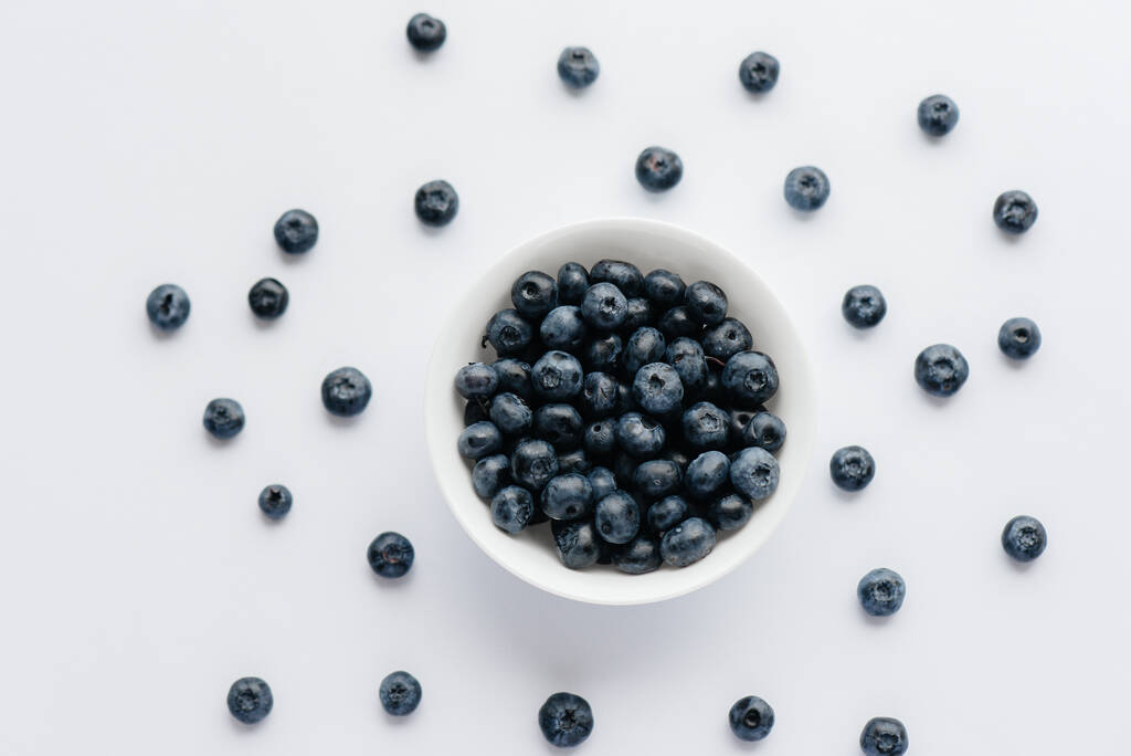 Beautiful ripe blueberries in a glass bowl on a white background. Healthy food, and vitamins. - Photo, Image