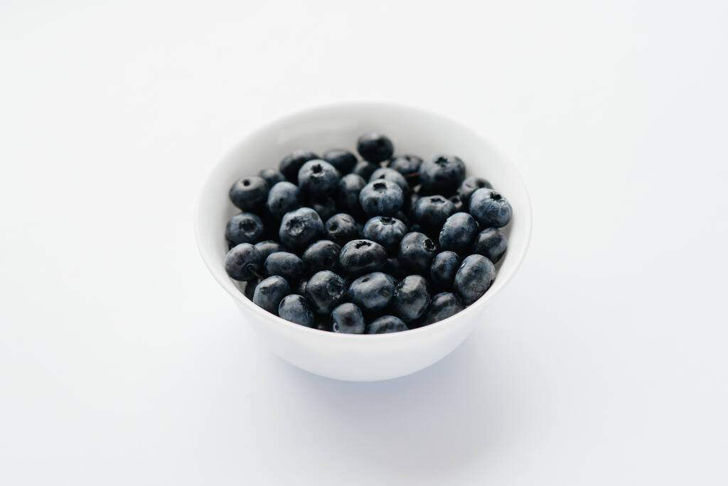 Schöne reife Blaubeeren in einer Glasschale auf weißem Hintergrund. Gesunde Ernährung und Vitamine. - Foto, Bild