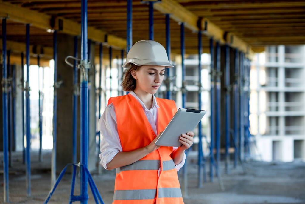 Construction concept of Engineer or Architect working at Construction Site. A woman with a tablet at a construction site. Bureau of Architecture. - Photo, Image