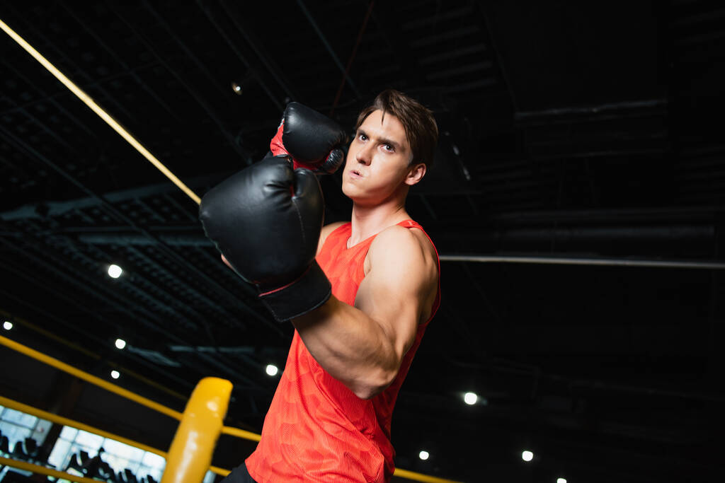 Athletischer Mann in Boxhandschuhen beim Training im Sportzentrum - Foto, Bild